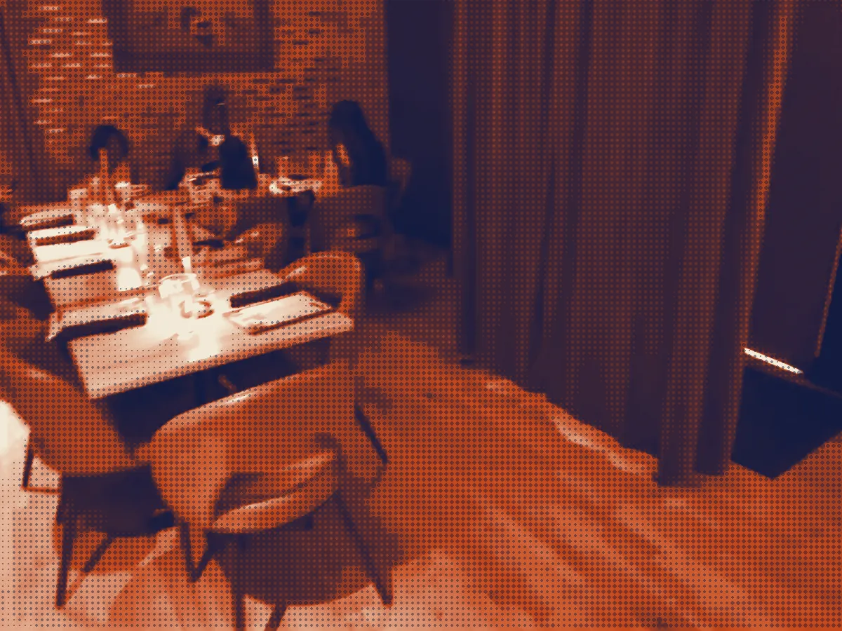 Lamp-lit tables beside a velvet curtain in the dining room